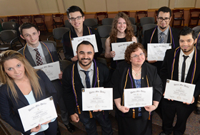 Delta Mu Delta students holding their diplomas